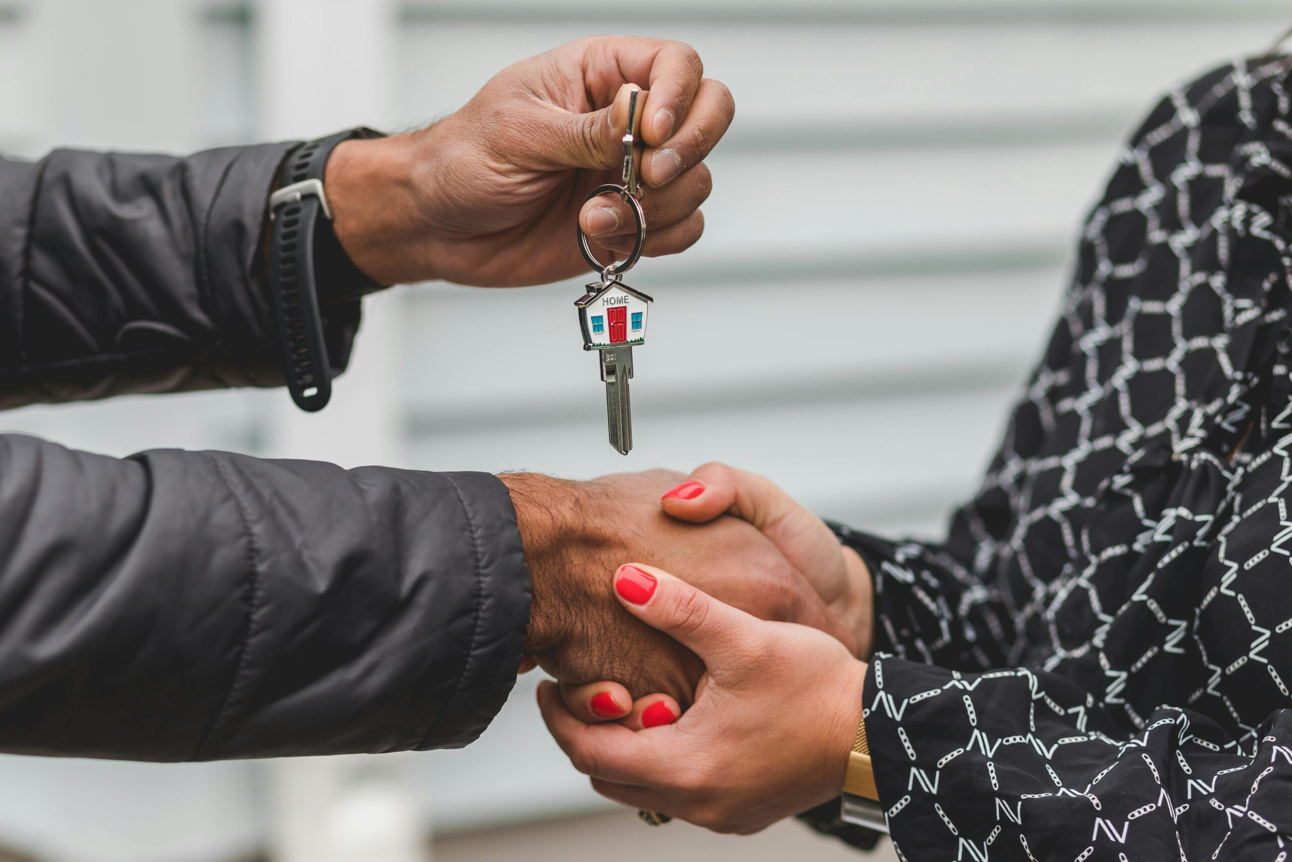 Image of someone handing over a key to someone